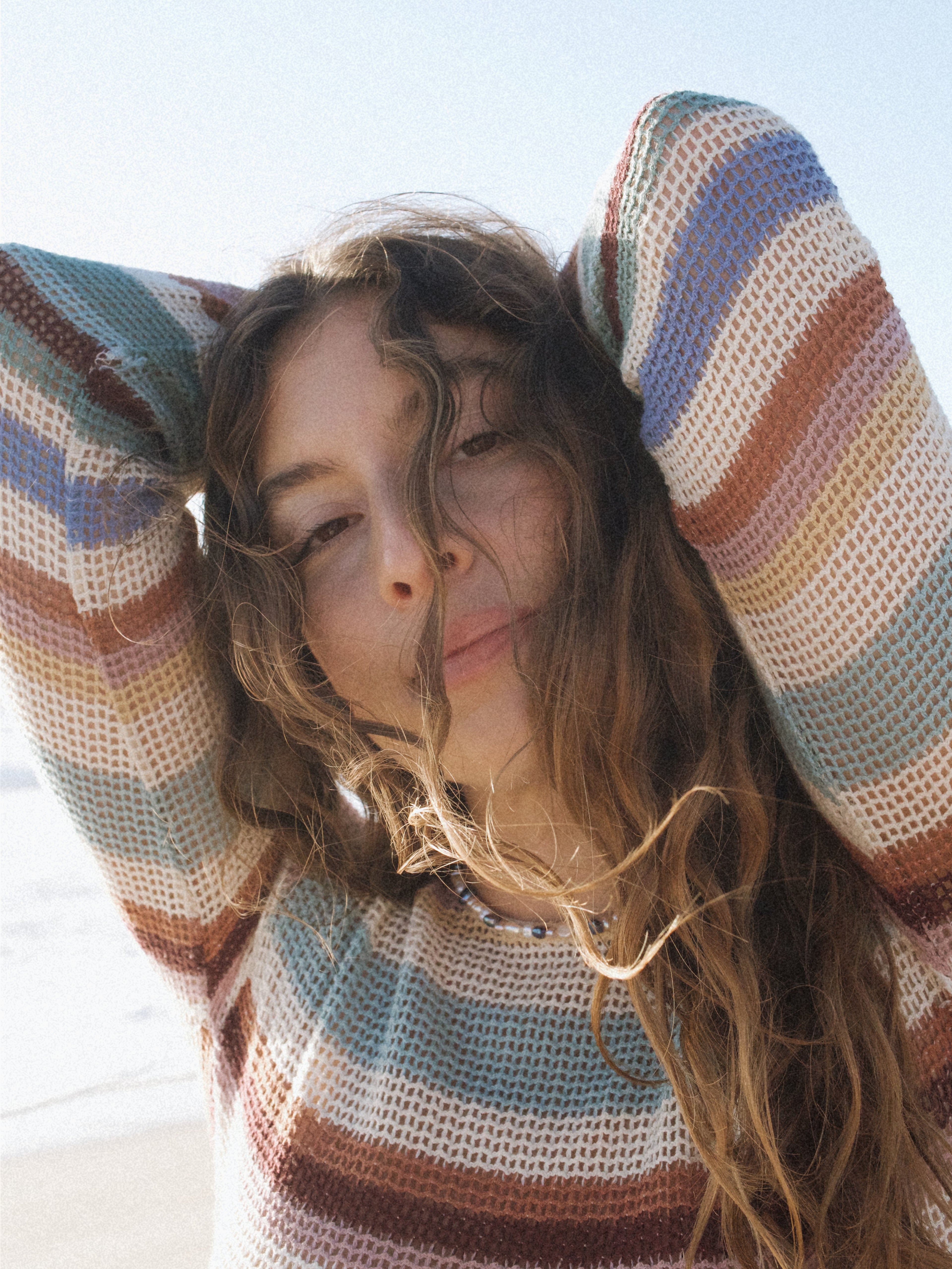 Woman wears a colorful Keshi pearl necklace with gold-filled components and a colorful dress. 